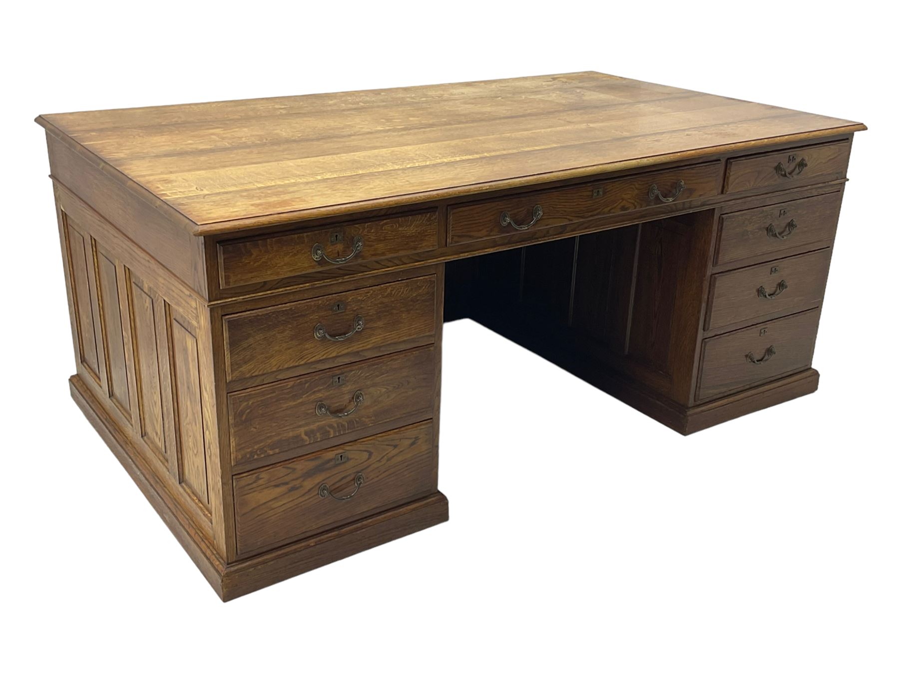 Large 20th century oak twin pedestal desk, moulded rectangular top over nine drawers, panelled pedestals, on moulded plinth base 