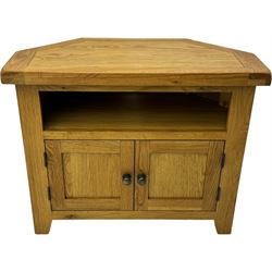 Light oak corner television unit, hexagonal top over recess with rear cable hole, fitted with two panelled doors to base and brass knobs 