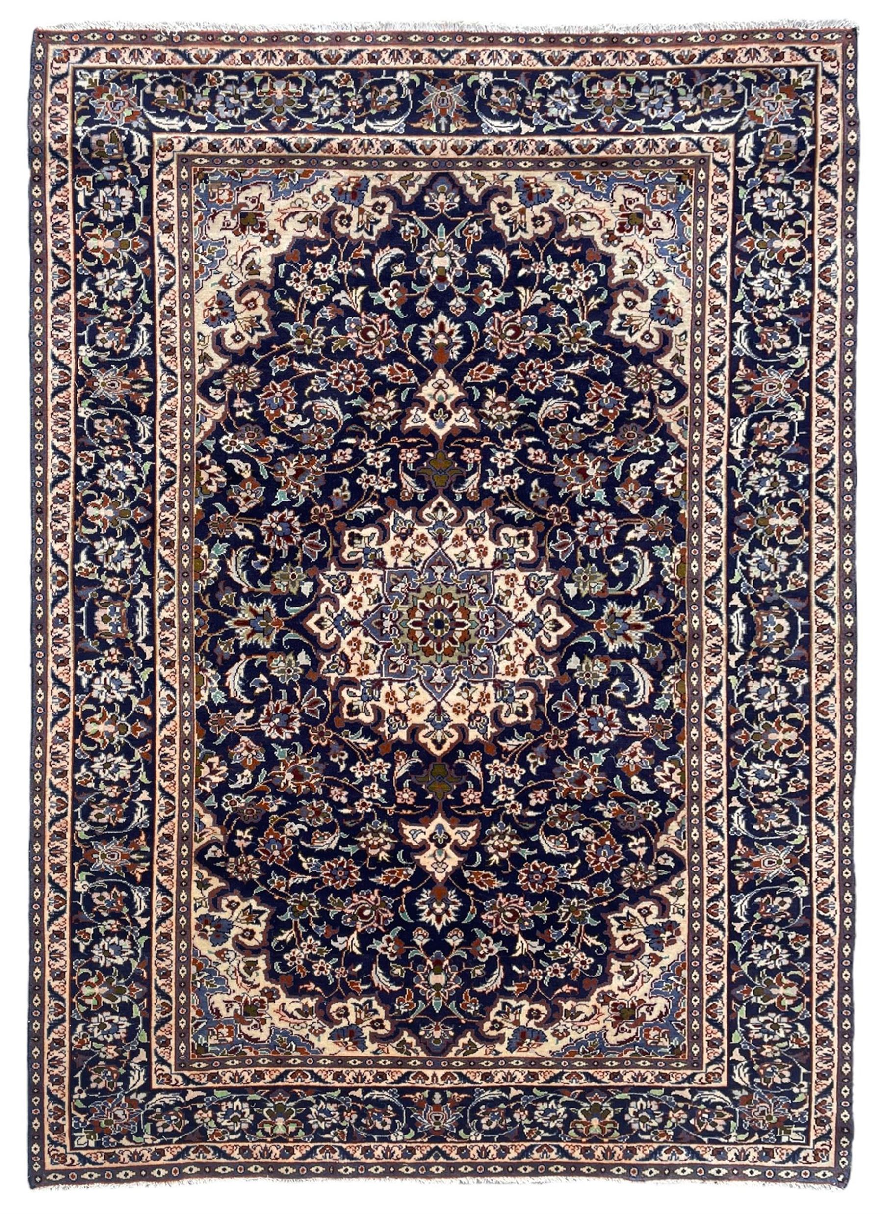 Persian Nain indigo ground, arabesque design, central start medallion surrounded by interlacing branches and palmettes, scrolling border with repeating stylised plant motifs, within guard stripes