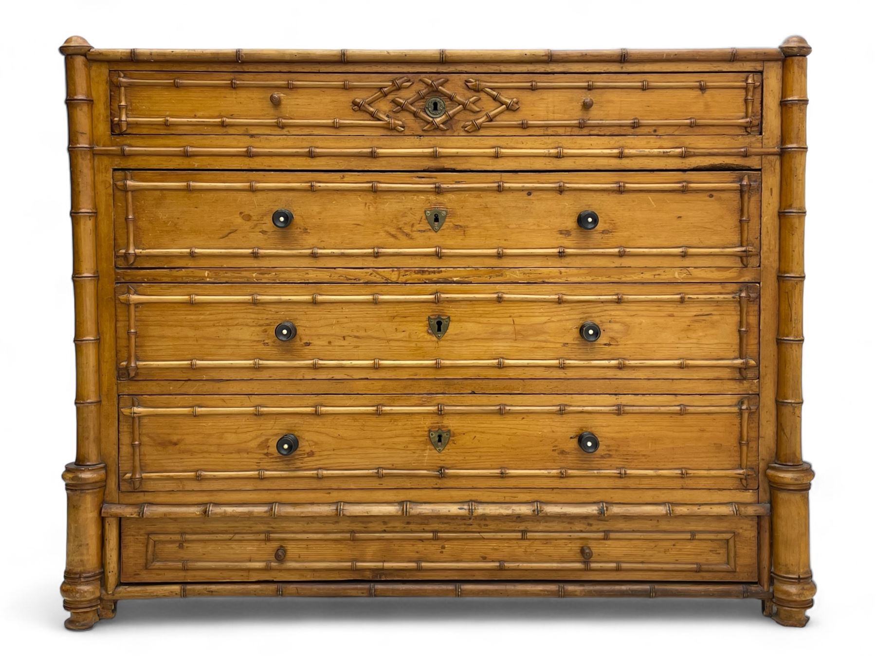 Victorian pine and simulated bamboo chest, fitted with five drawers, the drawer fronts decorated with applied simulated bamboo mounts and turned ebonised handles, on turned front feet