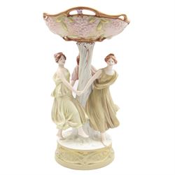 Royal Dux centrepiece, modelled as the Three Graces beneath a floral compote, upon a circular base, H51cm