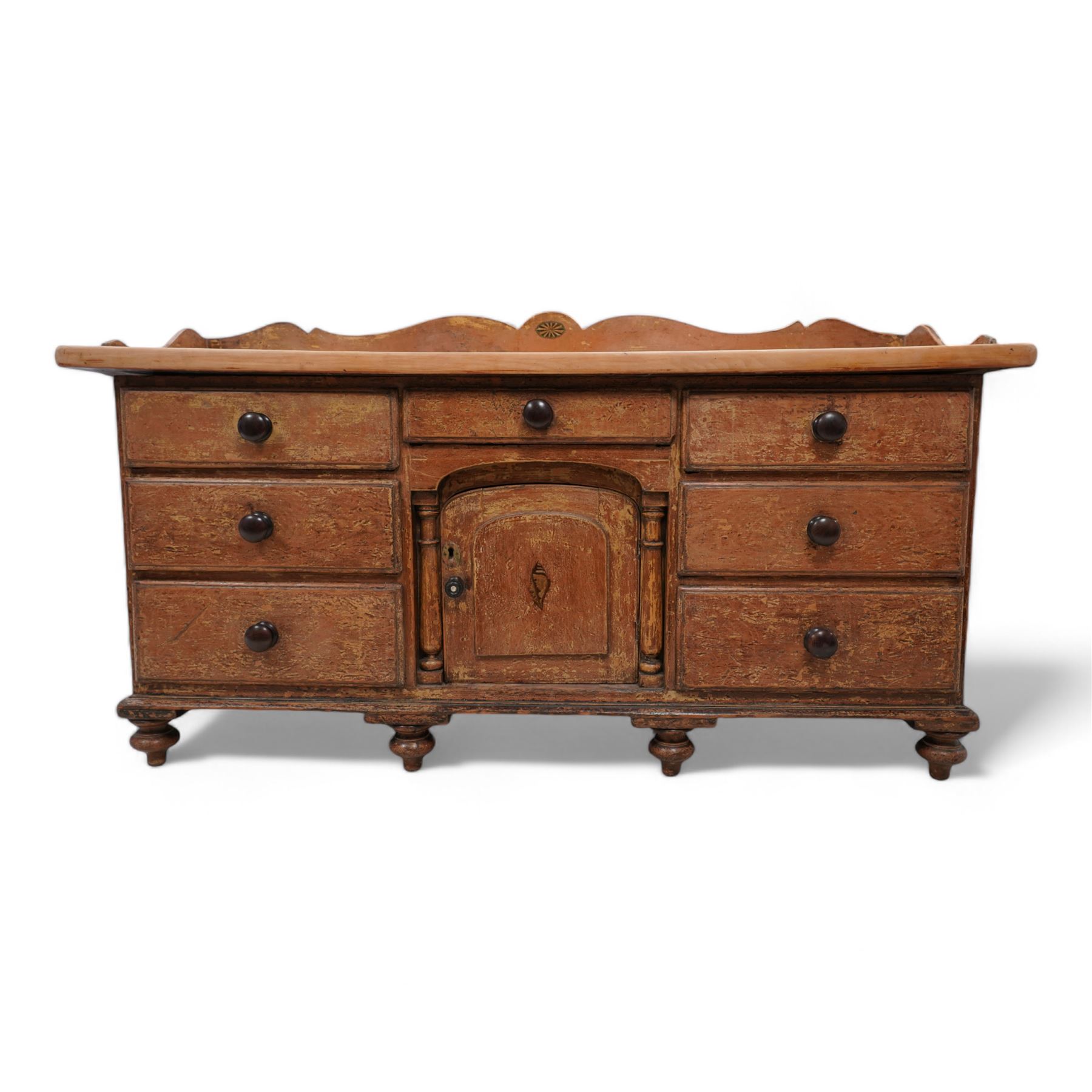 Victorian scumbled pine and sycamore dresser base, the sycamore top framed within shaped gallery, fitted with seven drawers and central cupboard enclosed by half columns mounts, on turned feet 