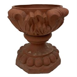 Pair of late 19th to early 20th century red terracotta garden urn planters, the shallow bowls moulded with curled acanthus leaf decoration, on circular foot with globular beaded moulding, octagonal base