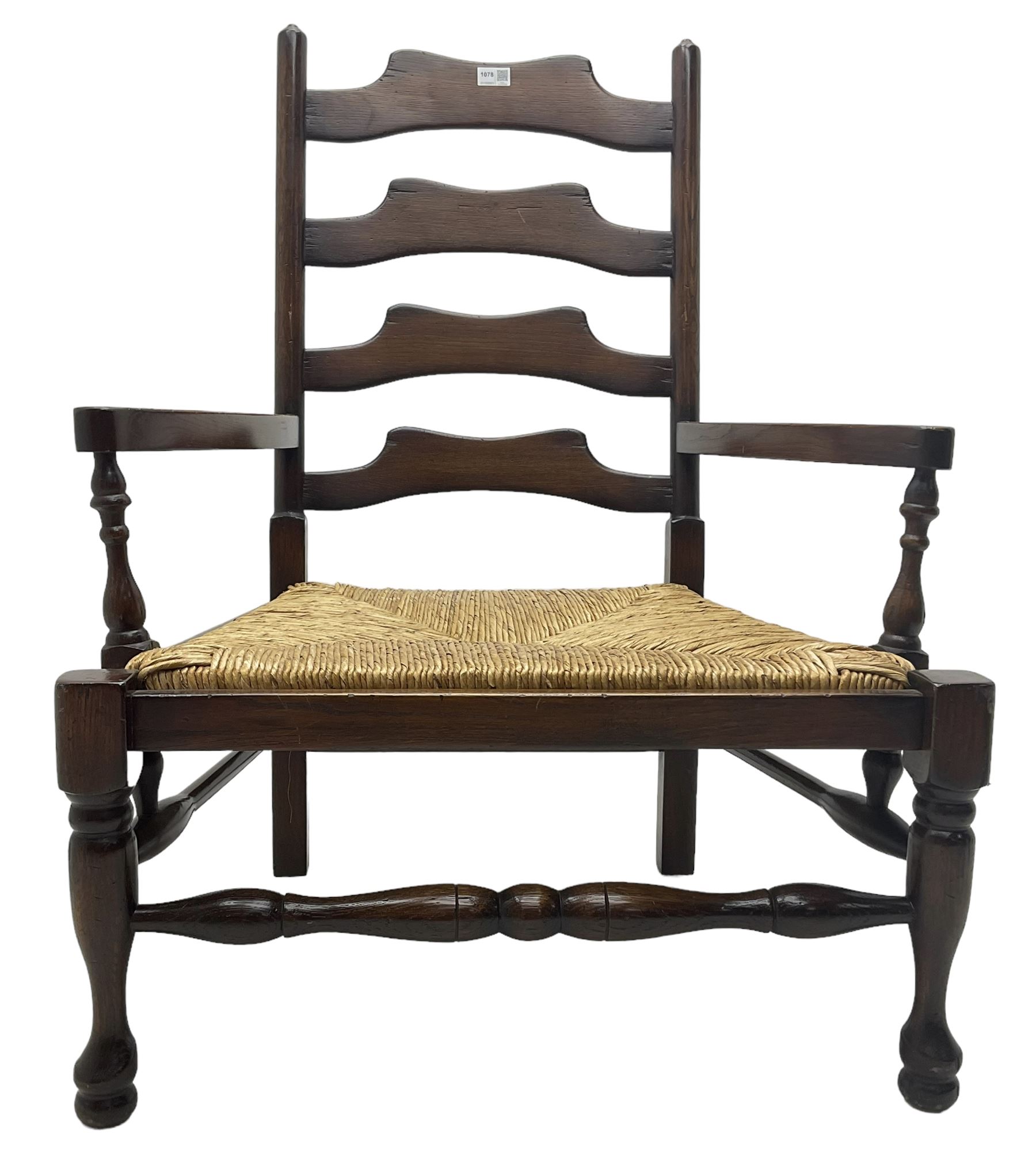 Georgian design oak country low armchair, waived ladder back over rush seat, raised on turned  supports united by stretchers; together with matching stool