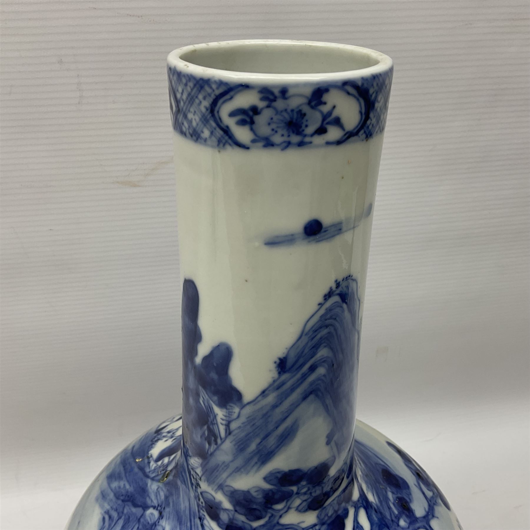 Late 18th/early 19th century Chinese blue and white bottle vase, decorated with a landscape scene containing dwellings, prunus and pine trees, boats and bridges, and populated with figures, with character mark beneath, H35cm