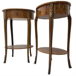 Pair of early 20th century French walnut bedside stands, oval bookmatched and cross-banded top fitted with single drawer, raised on cabriole supports united by undertier, decorated with floral gilt metal mounts