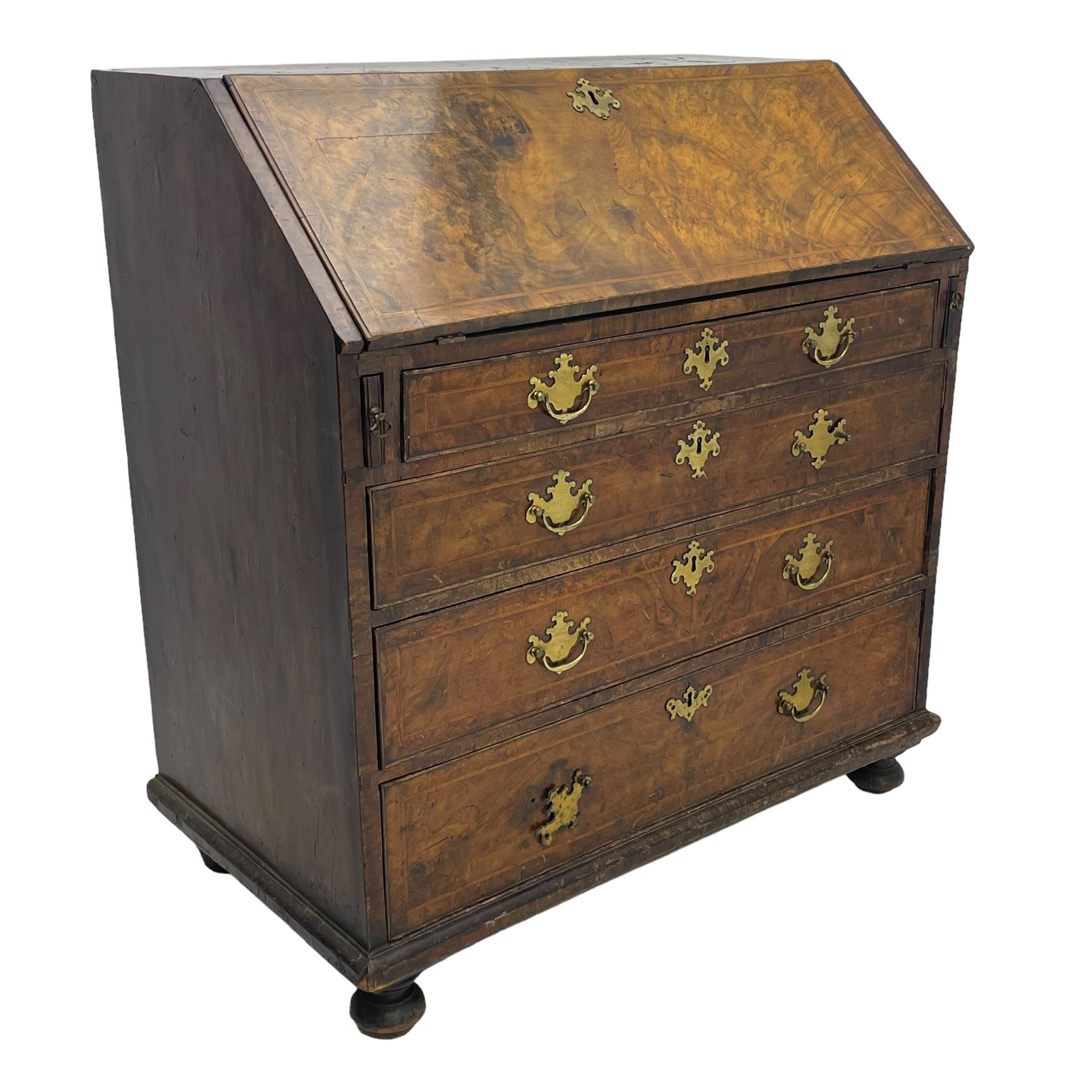 George I figured walnut bureau, hinged fall front enclosing drawers, pigeon holes and slide revealing storage well, fitted with four long cock-beaded and graduating drawers, shaped brass handle plates and escutcheons, on turned bun feet 