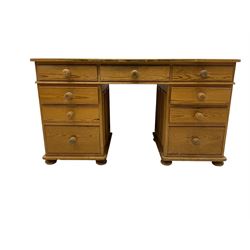 Waxed pine twin pedestal desk, rectangular top over nine drawers, on compressed bun feet 