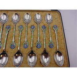 Set of twelve silver coffee spoons, each with enamelled blue flower to terminal and green and white enamel decoration to stem, hallmarked Mappin & Webb Ltd, Birmingham 1934, contained within fitted case