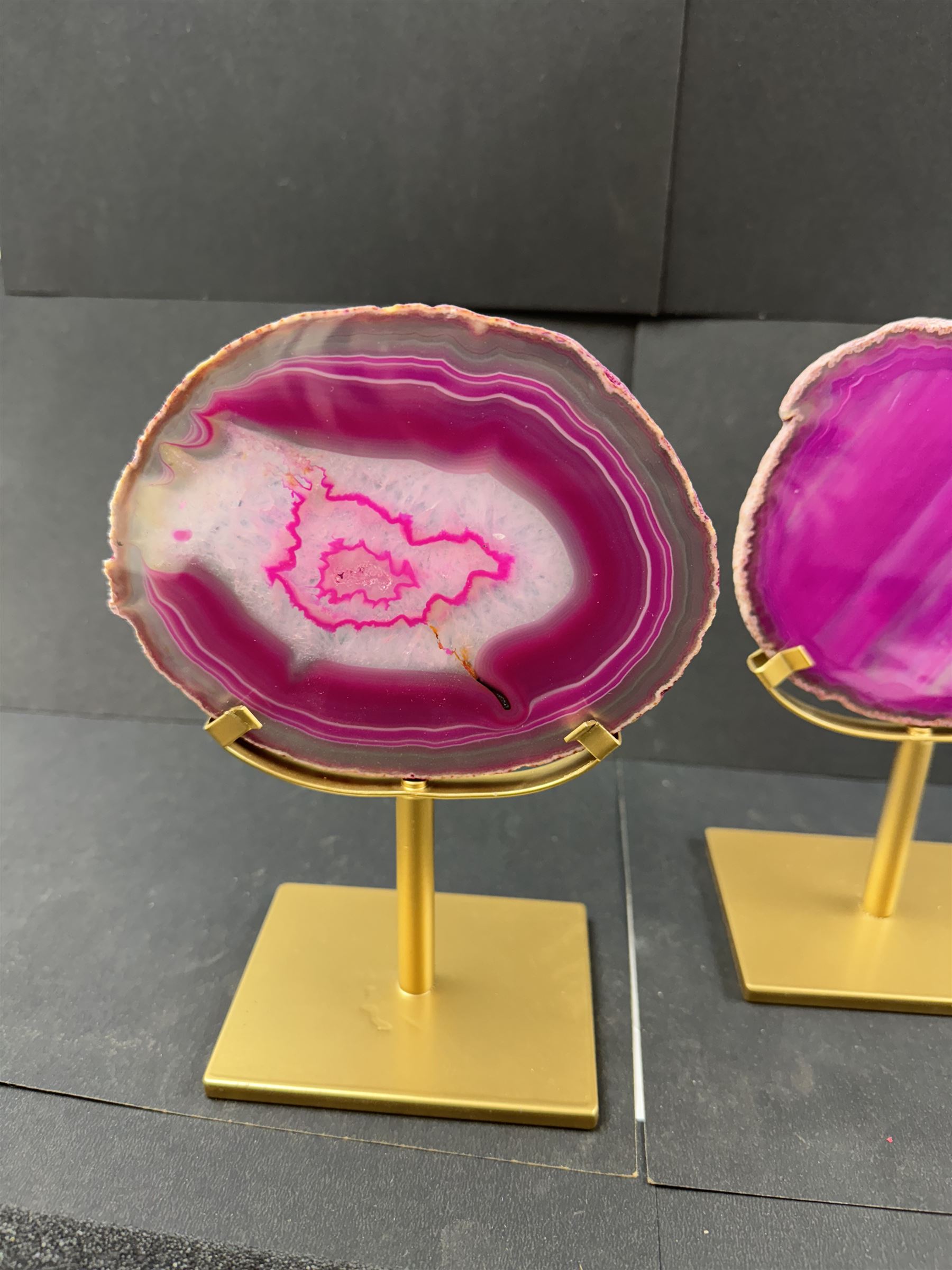 Pair of pink agate slices, polished with rough edges, raised upon gilt metal stands, H20cm