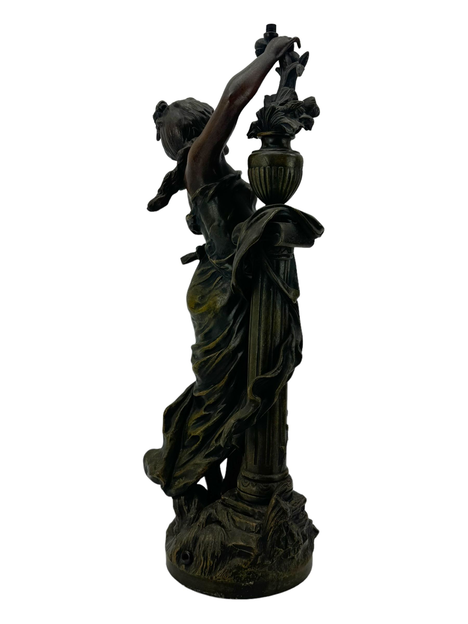 After L & F Moreau - Spelter table lamp in the form of a female figure next to a pedestal on circular naturalistic base H55cm