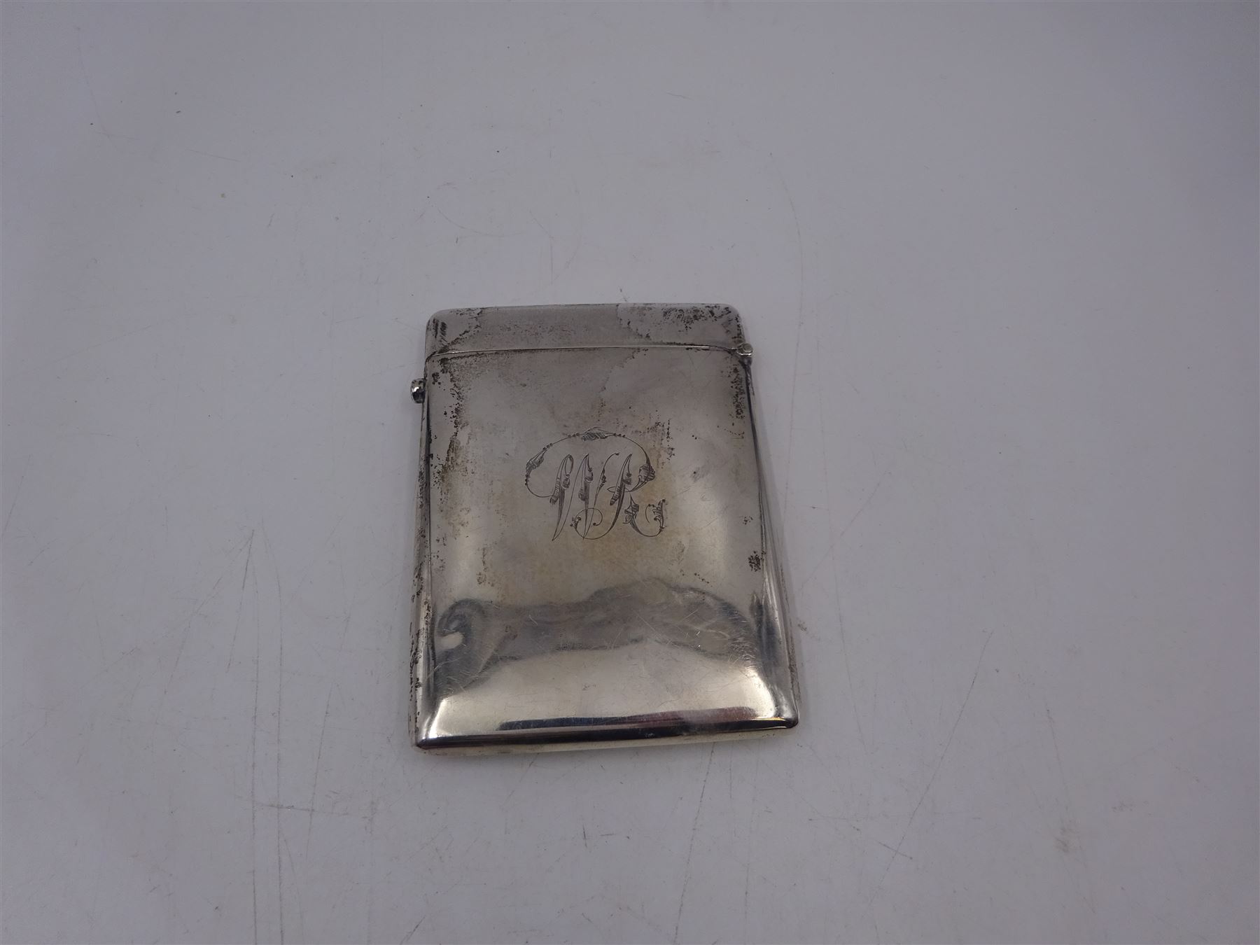 Late Victorian silver card case, of rectangular form with rounded corners, embossed with four putti amongst clouds, engraved with initials verso, hallmarked Henry Matthews, Birmingham 1900, H10.5cm