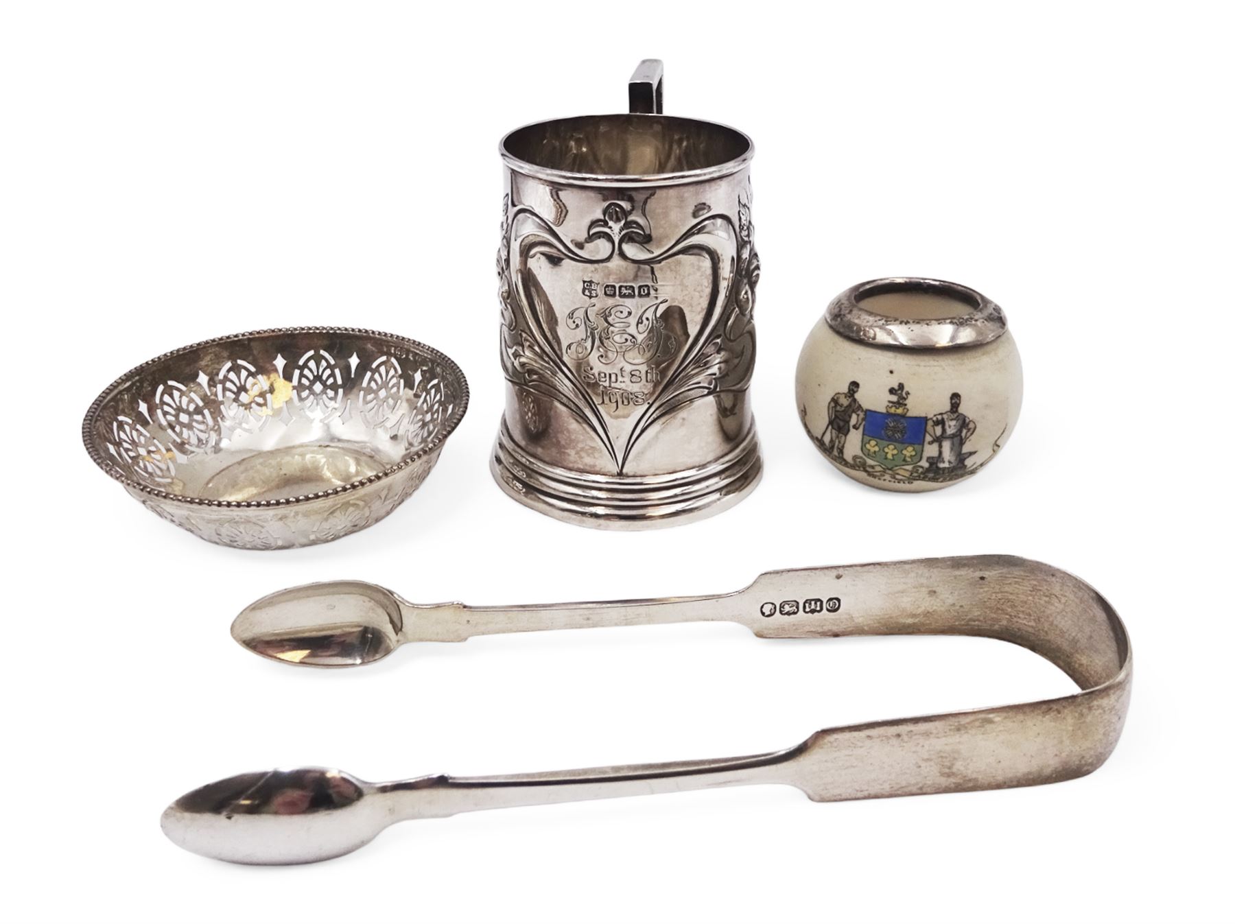 Group of silver, comprising Edwardian christening mug, of slightly tapering form, embossed with floral decoration and engraved initials and date, hallmarked Cooper Brothers & Sons Ltd, Sheffield 1906, a crested ware jar with silver collar, pierced pin dish and a pair of sugar tongs, all hallmarked 