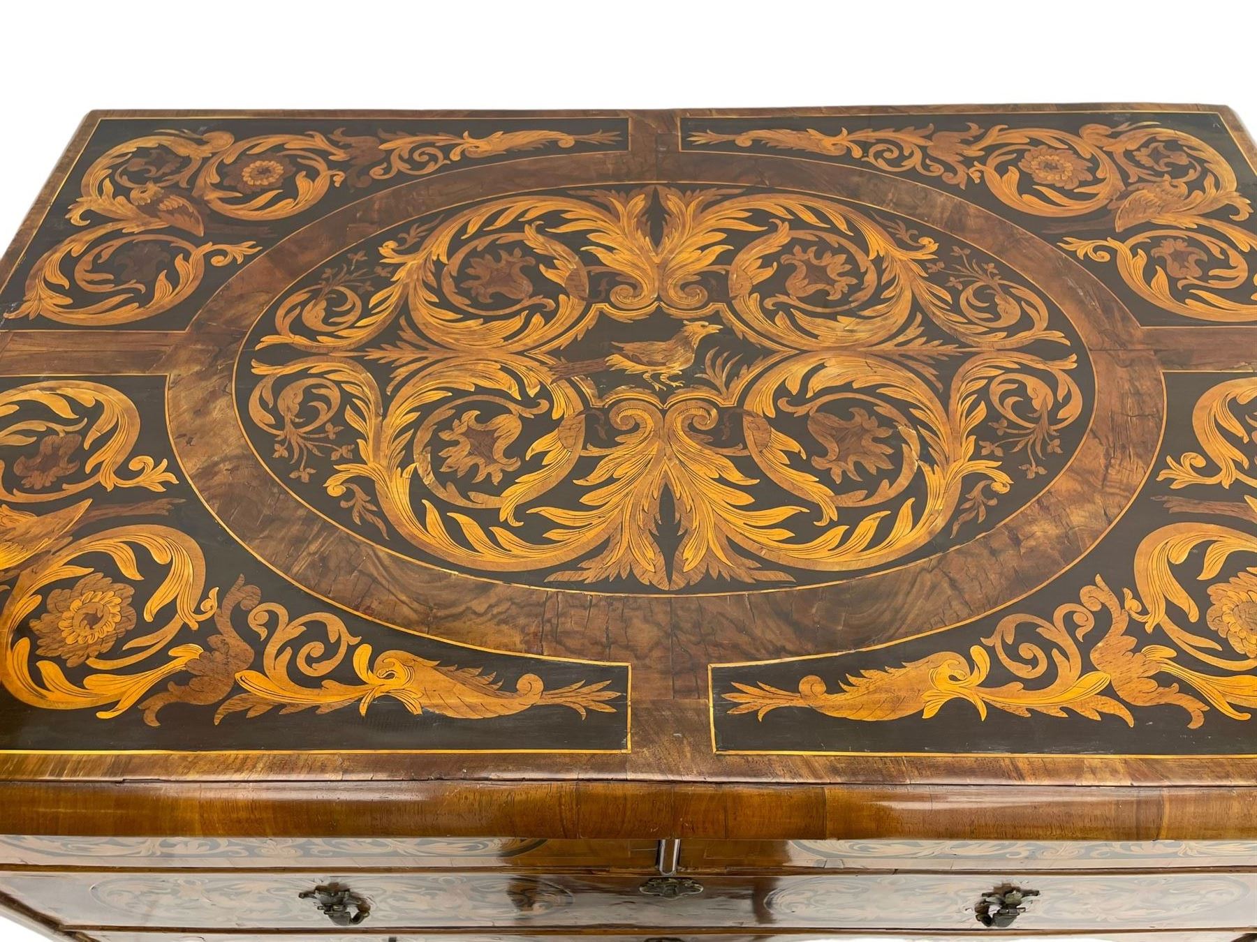 18th century inlaid walnut chest on stand, ovolo-moulded rectangular top inlaid with ebony panels each decorated with scrolling foliage, flower heads and birds, fitted with two short over three long drawers, the drawer fronts decorated with ebony panels enclosing curled leaf inlays, the base fitted with single drawer on turned supports united by waved stretchers, on turned bun feet 