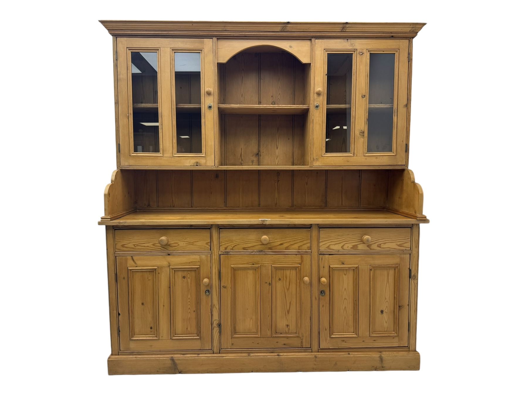 Large pine dresser, raised display cabinets over three drawers and three panelled cupboards, on plinth base