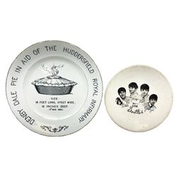 RTV - UNSOLD TWICE Early 20th century commemorative plate depicting a black transfer image of a steaming pie with text surrounding reading 'Denby Dale Pie in aid of the Huddersfield Royal Infirmary', marked H.G.D.D to reverse, D24cm, and a The Beatles plate