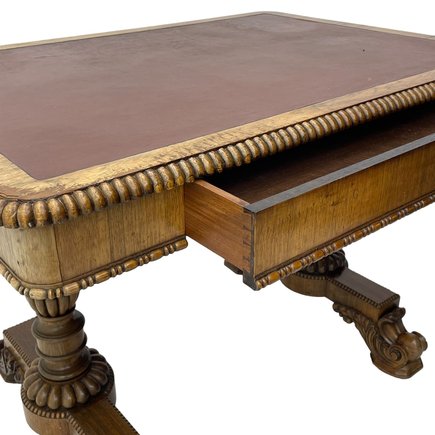 Early 19th century Regency rosewood writing table, rectangular top with inset leather writing surface and gadroon moulded edge, fitted with single frieze drawer, on twin turned pillar supports with lobe carved balusters, on platforms with beaded edge, acanthus scroll carved feet