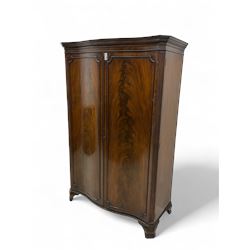 Early 20th century mahogany serpentine double wardrobe, moulded cornice over two figured d...