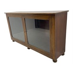 Early 20th century mahogany bookcase, rectangular top over two glazed doors, fitted with four adjustable shelves, on turned bun feet 