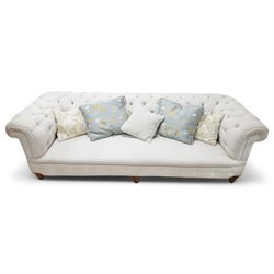 Victorian oak framed three seat Chesterfield sofa, traditional shape, upholstered in deep buttoned ivory and blue patterned fabric, raised on turned feet, with loose scatter cushions