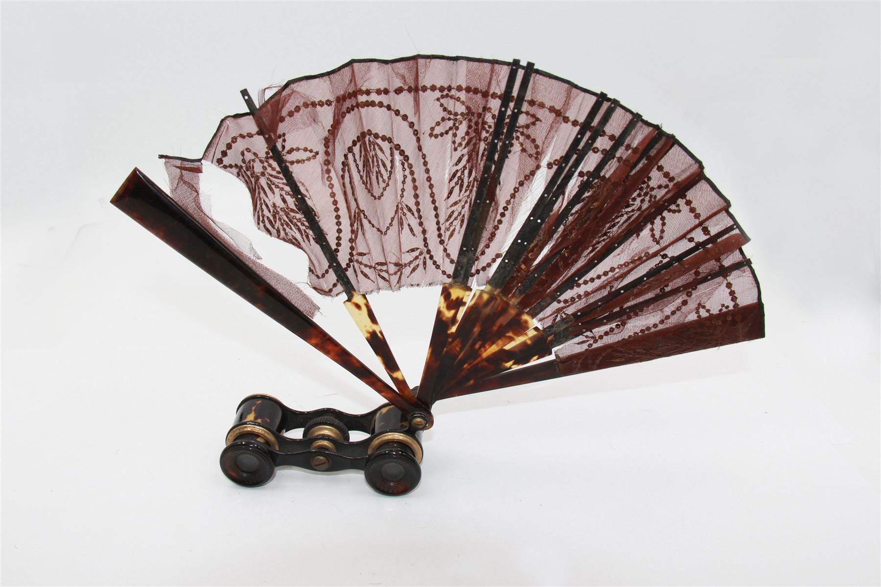 Early 20th century Asprey & Co opera glasses, with simulated tortoiseshell body and handle, the handle opening to reveal a chiffon fan, finely worked with sequins, stamped Asprey & Co London