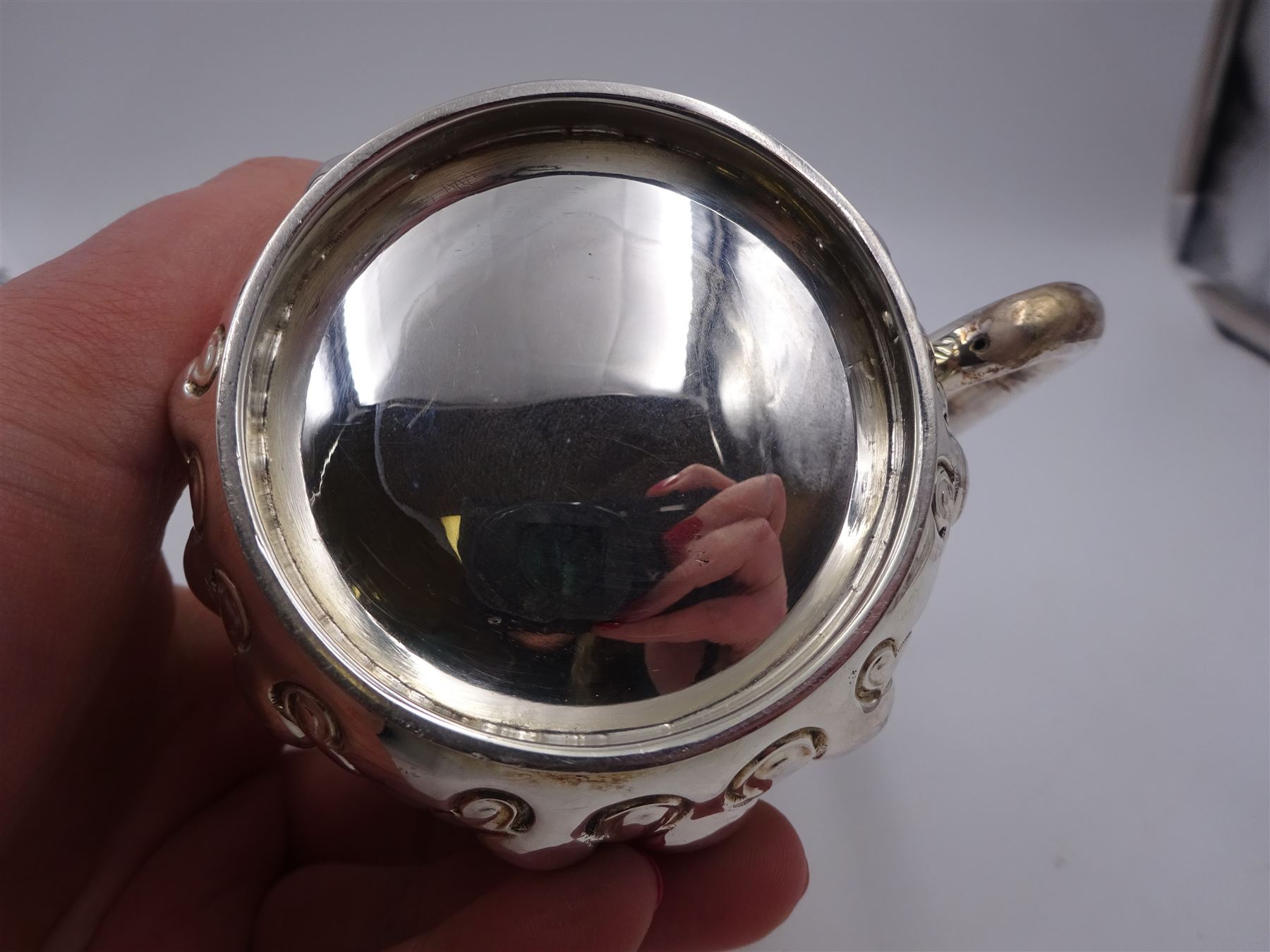 Late Victorian silver christening mug, with C handle and gilt interior, the body profusely embossed with floral and foliate decoration, hallmarked Atkin Brothers, Sheffield 1897, H10cm