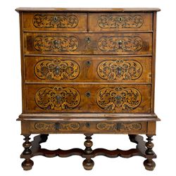 18th century inlaid walnut chest on stand, ovolo-moulded rectangular top inlaid with ebony panels each decorated with scrolling foliage, flower heads and birds, fitted with two short over three long drawers, the drawer fronts decorated with ebony panels enclosing curled leaf inlays, the base fitted with single drawer on turned supports united by waved stretchers, on turned bun feet 