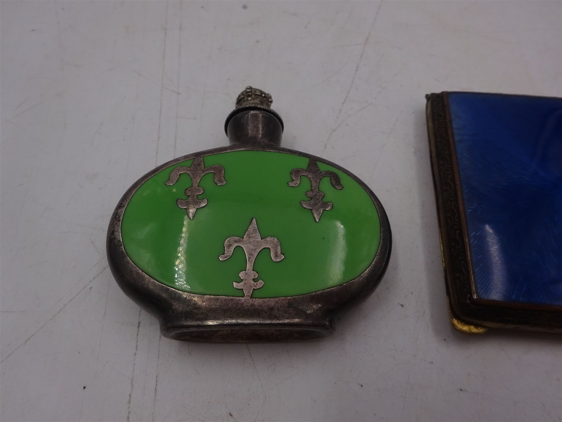 Early 20th century small brass cigarette case, with guilloche enamel panel to hinged cover, together with a silver plated ceramic scent bottle, cigarette case H6cm