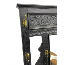 Victorian oak hall stand, the upper section featuring eight brass hooks and central mirror plate flanked by scroll-carved panels, the central section includes a storage box positioned above an umbrella stand, supported by square carved legs with scroll-carved horizontal supports