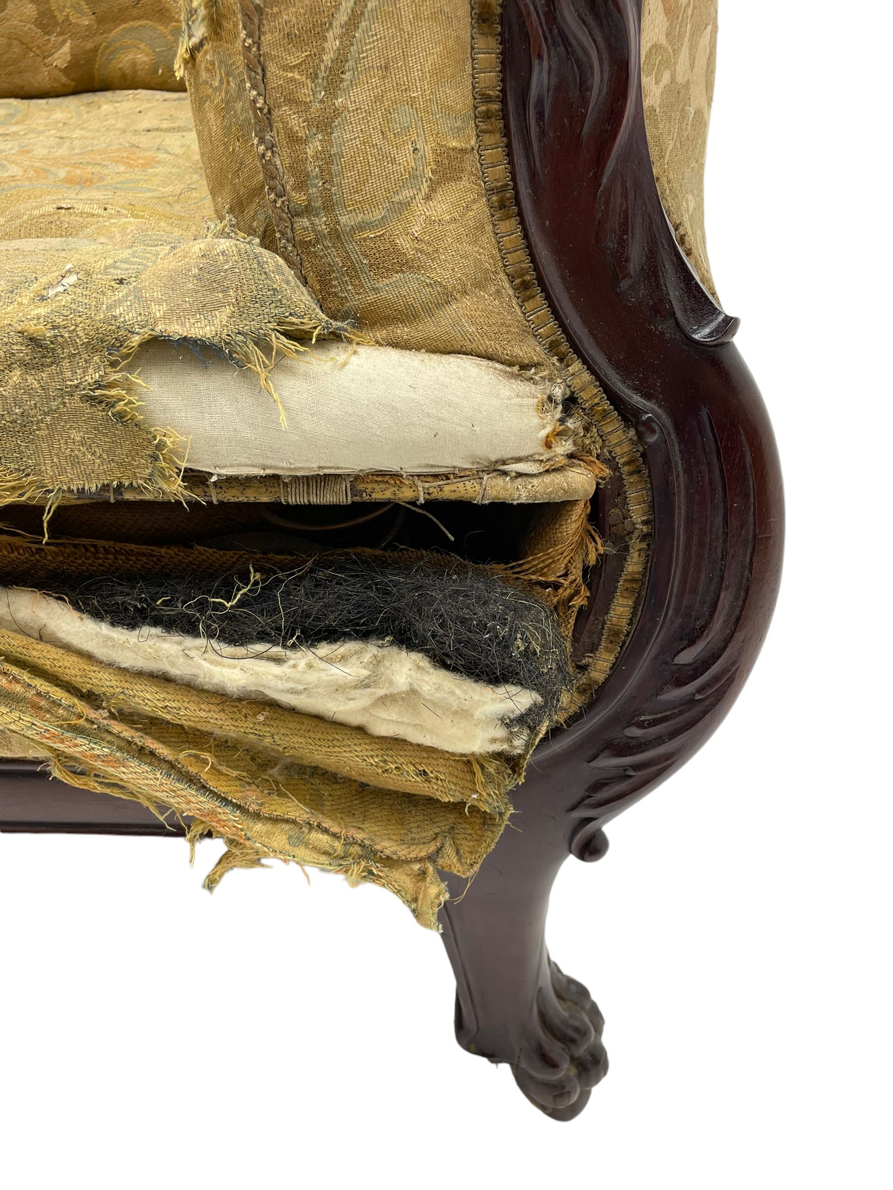 19th century mahogany settee, rolled S-scrolled arms carved with lion masks and acanthus leaf scrolls, the lower moulded rail carved with scrolling design, raised on carved paw feet with recessed brass and ceramic castors 