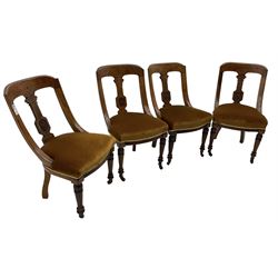 Set of four late Victorian walnut dining chairs, carved with stylised floral decoration and scrolling branches, upholstered seat, on turned and fluted supports 