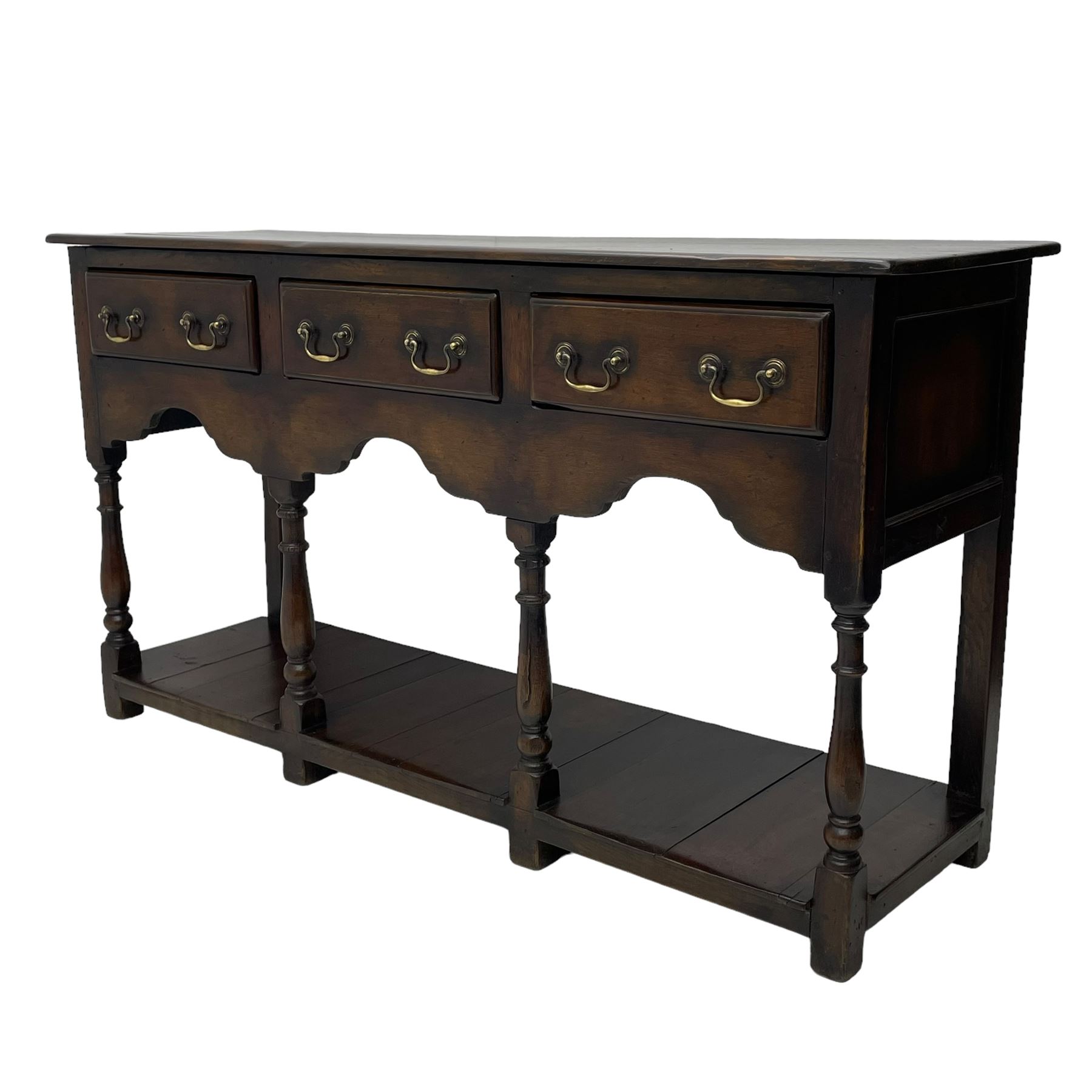 Georgian design oak dresser base, rectangular three plank top over three drawers and shaped apron, moulded drawer fronts with brass swan neck handles and circular plates, turned supports on panelled pot board base