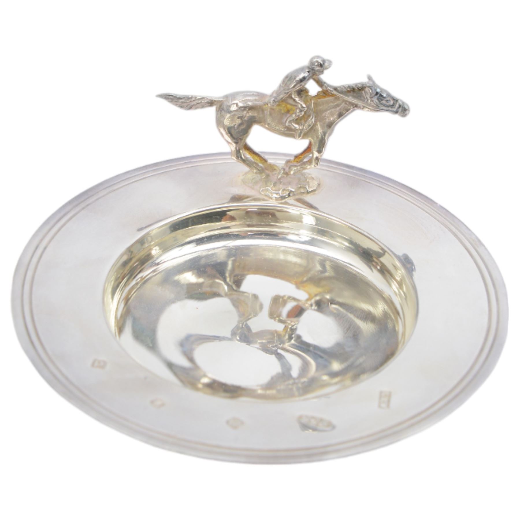 Three silver presentation dishes, two inscribed 'Newmarket Racecourses, The Home of Racing' and another mounted with a model of a racehorse with jockey up, Sheffield  2014, Britannia standard, Maker Laurence R Watson & Co, together with a silver plated dish inscribed 'Haydock Park Winner 2002' (4)