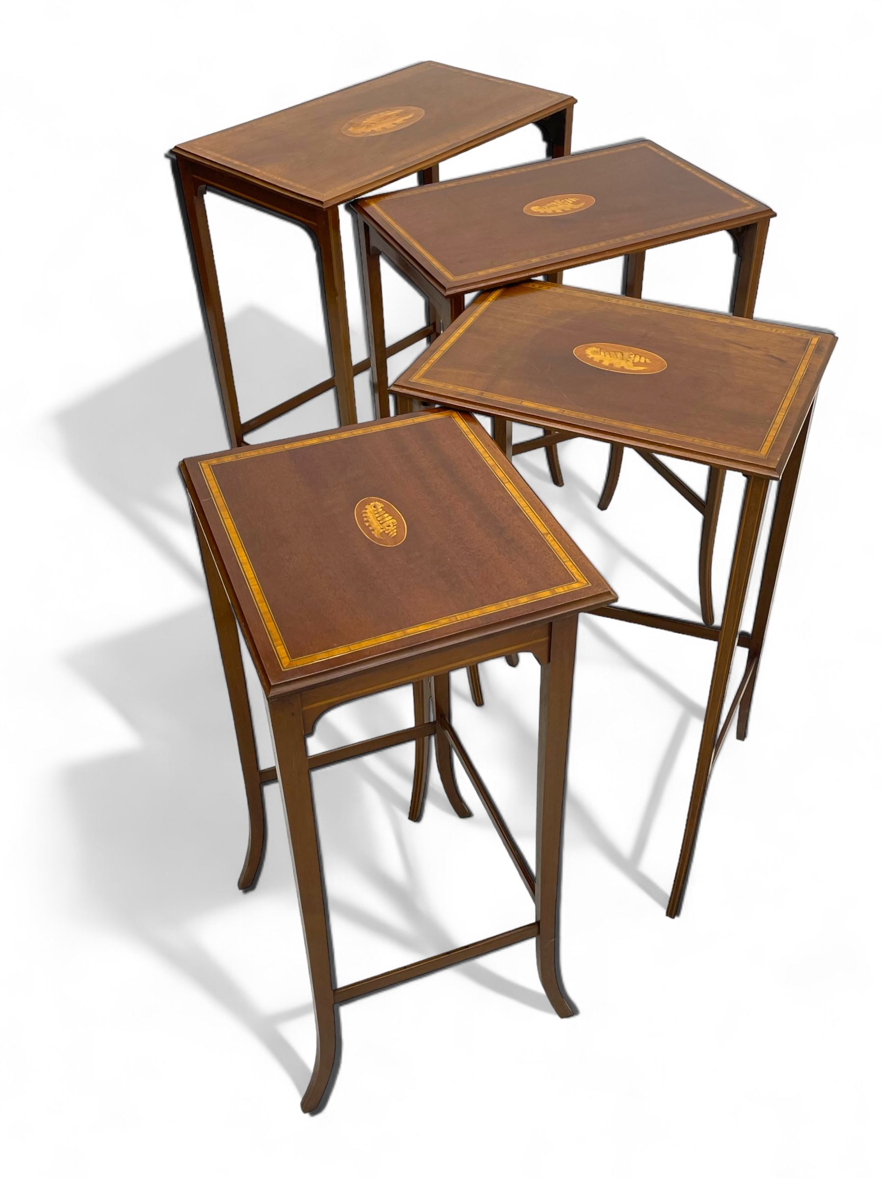 Edwardian inlaid mahogany quartetto nest of four occasional tables, each table with rectangular moulded top with satinwood band and central shell inlay, on square tapering supports with splayed terminals, inlaid with boxwood stringing