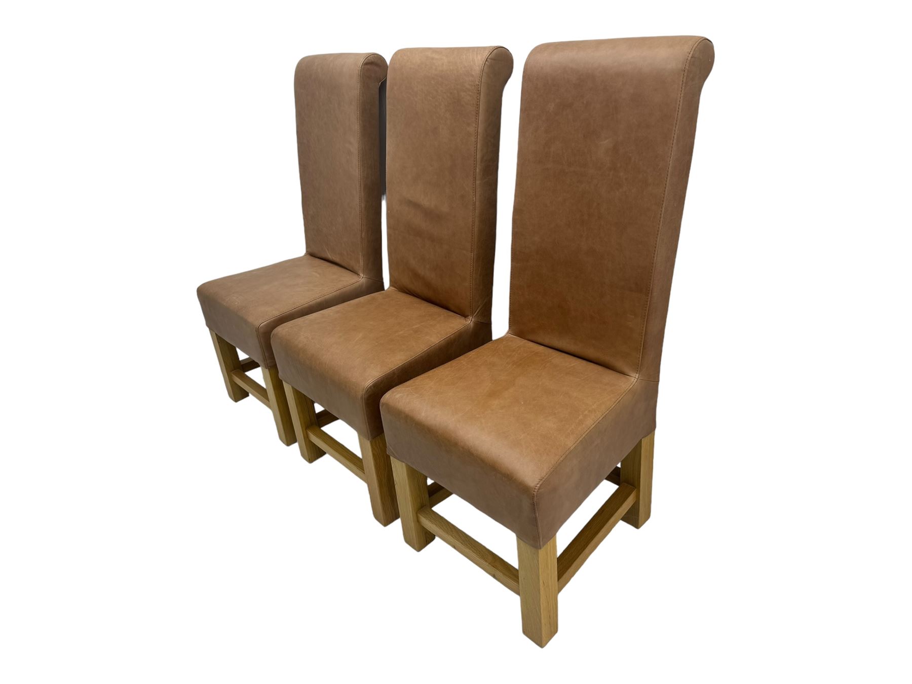 Set of six contemporary light oak dining chairs, each with high back and seat upholstered in pale tan leather, on square supports connected by H-stretcher