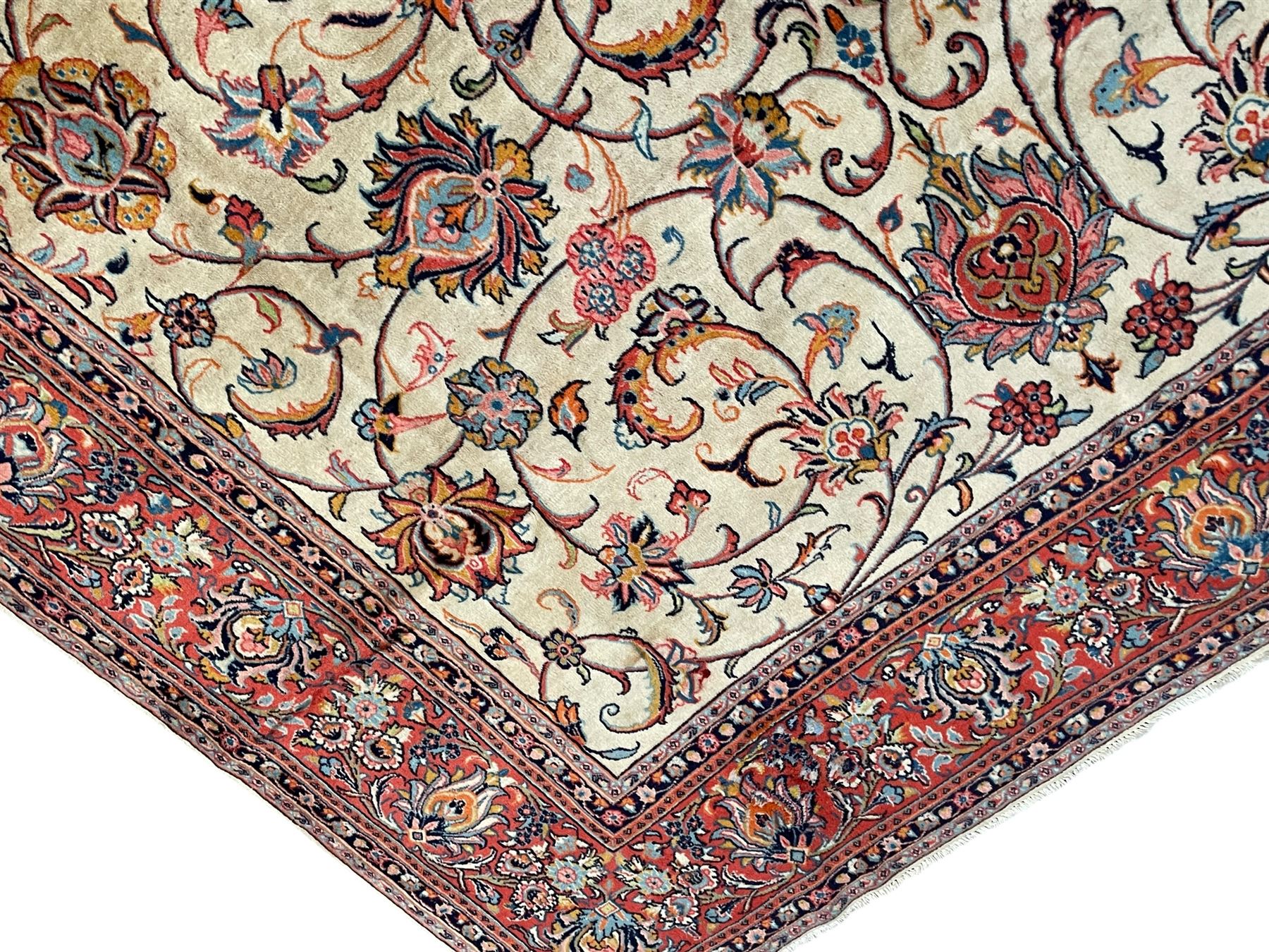 Persian Sarough ivory ground rug, the field decorated with curled leafy branches and palmettes, crimson ground border decorated with further palmettes and floral sprays, within guard stripes 