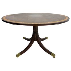 Georgian design inlaid chestnut wood centre table, the circular tilt-top inlaid with satinwood banding, gun barrel turned pedestal on four out-splayed supports, cast brass hairy paw castors, stamped 'P.H.R & Co. Holt, England' 