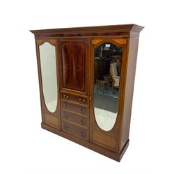 Edwardian inlaid mahogany combination wardrobe, projecting moulded cornice over figured frieze with satinwood banding, the central section fitted with cupboard over four long drawers, figured matched veneers and satinwood bands, flanked by two full height compartments enclosed by bevelled shield shaped mirror doors, satinwood fan inlaid spandrels, on moulded skirt base 