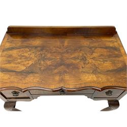 Mid-to-late 20th century figured walnut side table, raised back over figured top with cross banding and shaped front, fitted with three drawers, on cabriole supports with carved terminals 