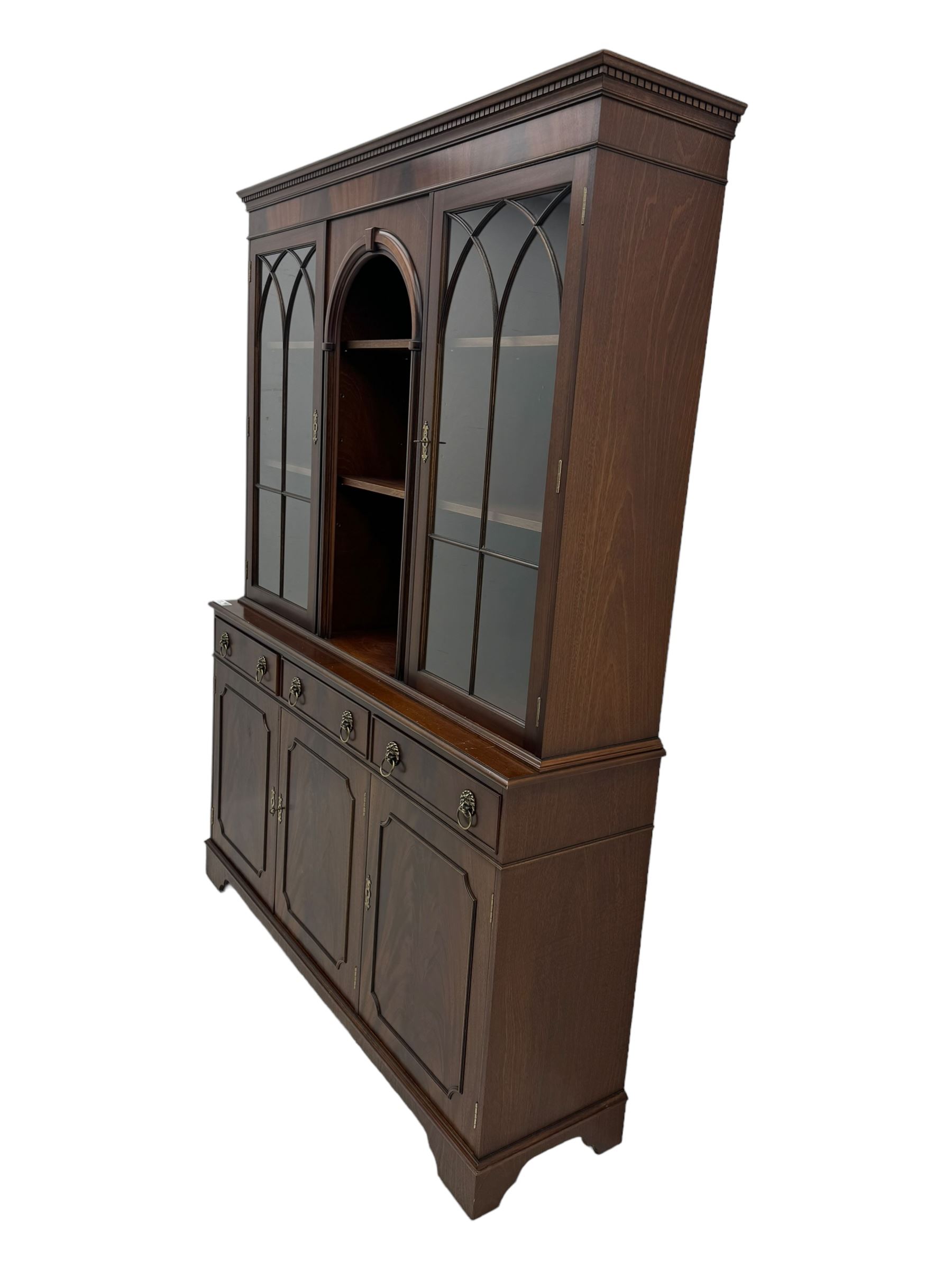 Georgian design mahogany bookcase on cupboard, projecting moulded and dentil cornice, two display cabinets enclosed by glazed doors above over three drawers and three cupboards, on bracket feet