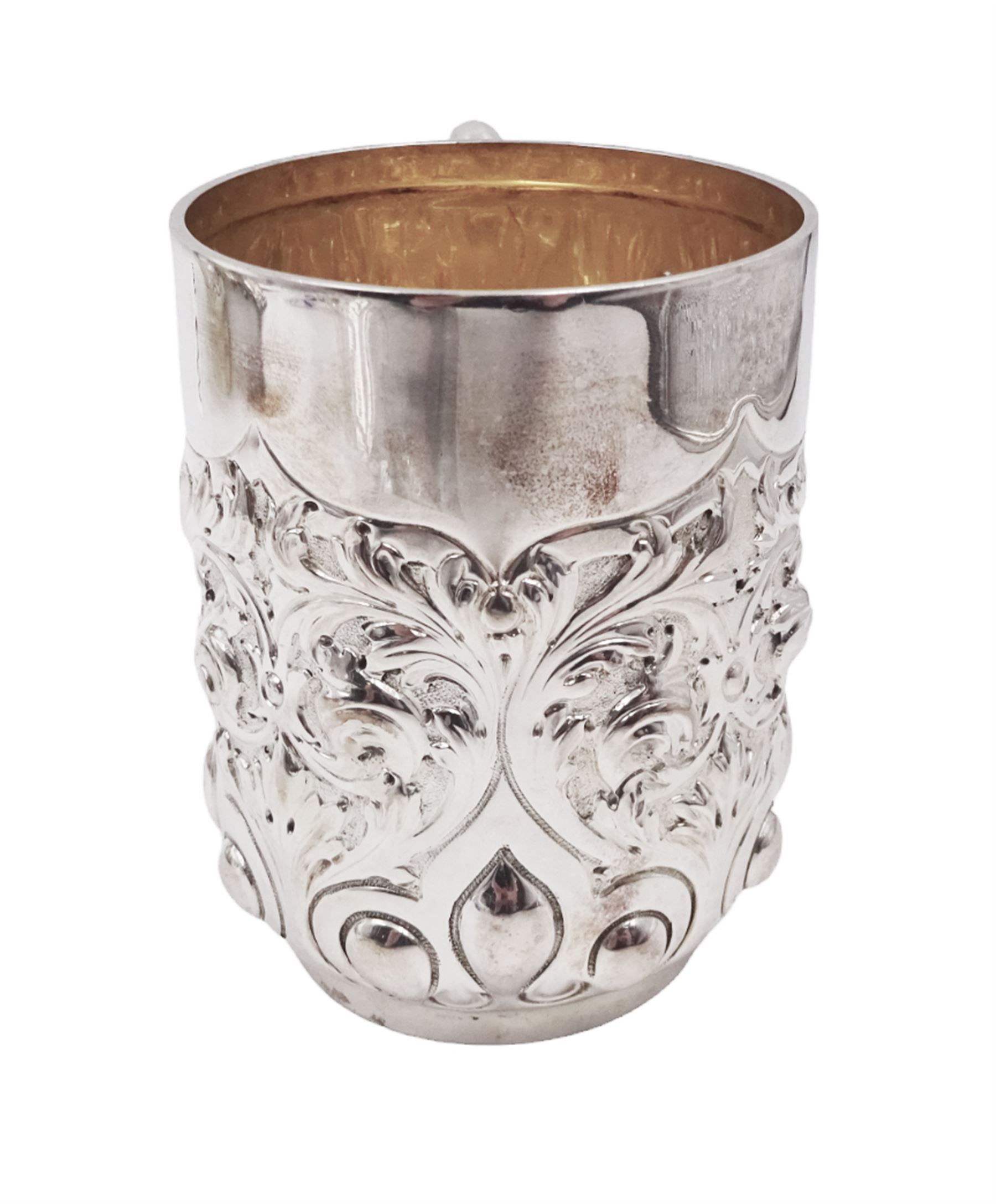 Late Victorian silver christening mug, with C handle and gilt interior, the body profusely embossed with floral and foliate decoration, hallmarked Atkin Brothers, Sheffield 1897, H10cm