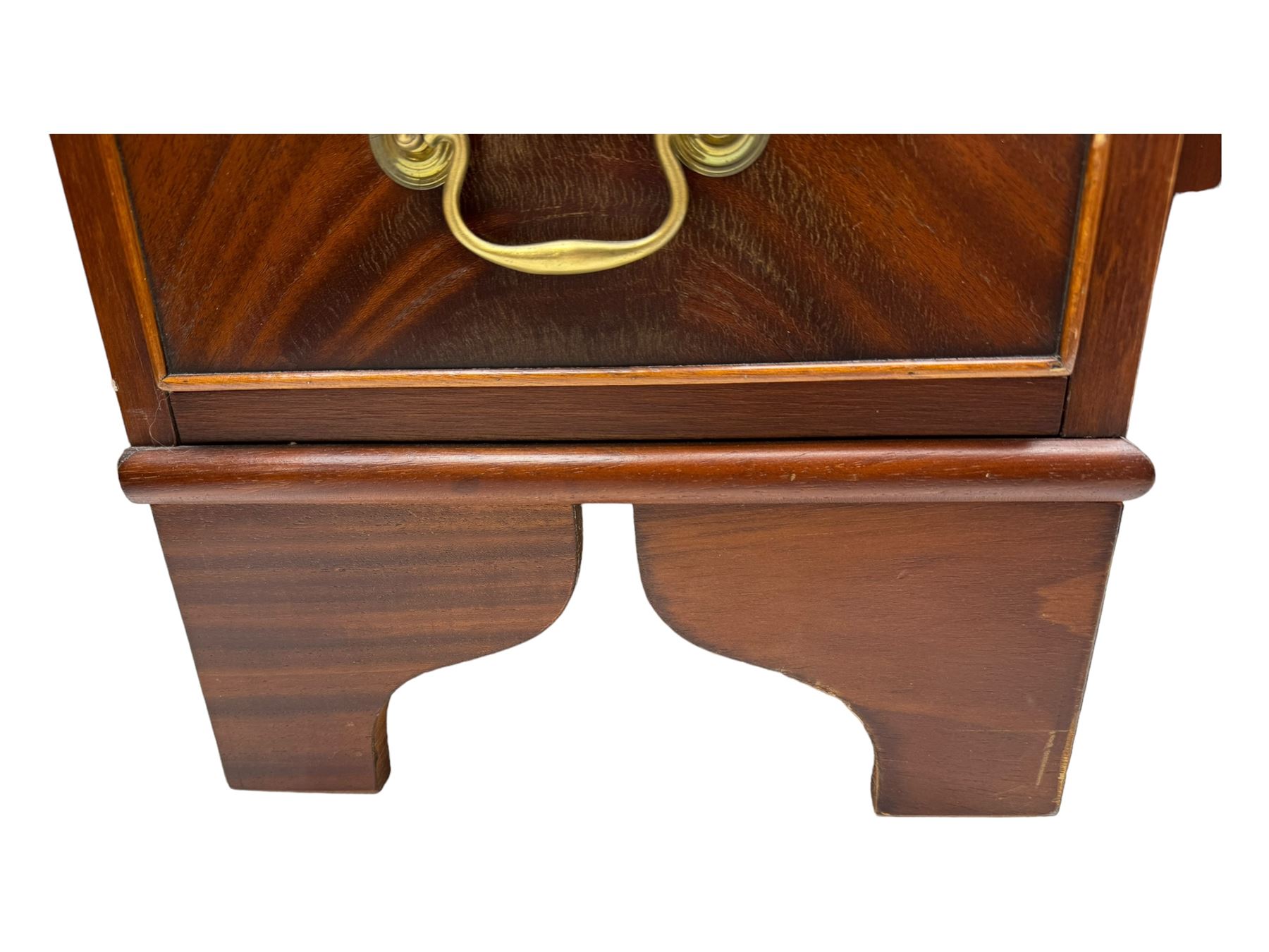 Late 20th century mahogany corner desk, leather inlaid top with gilt tooling, central frieze drawer flanked by two banks of four graduated drawers, raised on shaped bracket supports 