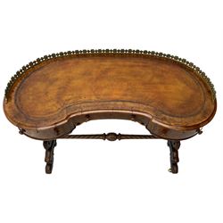 Victorian walnut kidney-shaped writing desk, moulded top with floral cast brass gallery and inset leather writing surface, fitted with three frieze drawers with turned handles, shaped and pierced end supports on raised platforms terminating to splayed feet, united by twist turned and lobe carved stretcher, brass and ceramic castors 