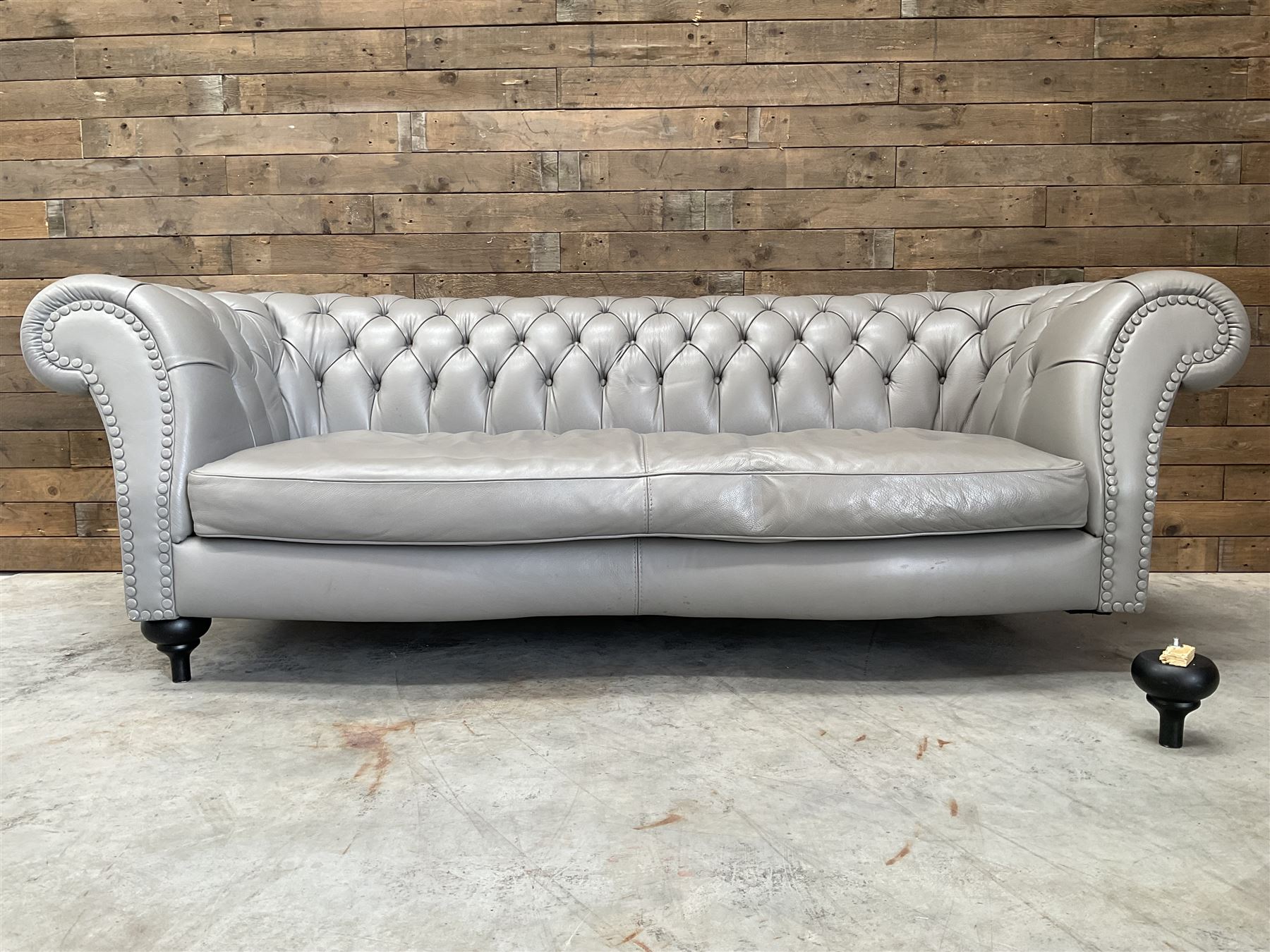 Three seat Chesterfield sofa, upholstered in grey buttoned leather - damaged leg