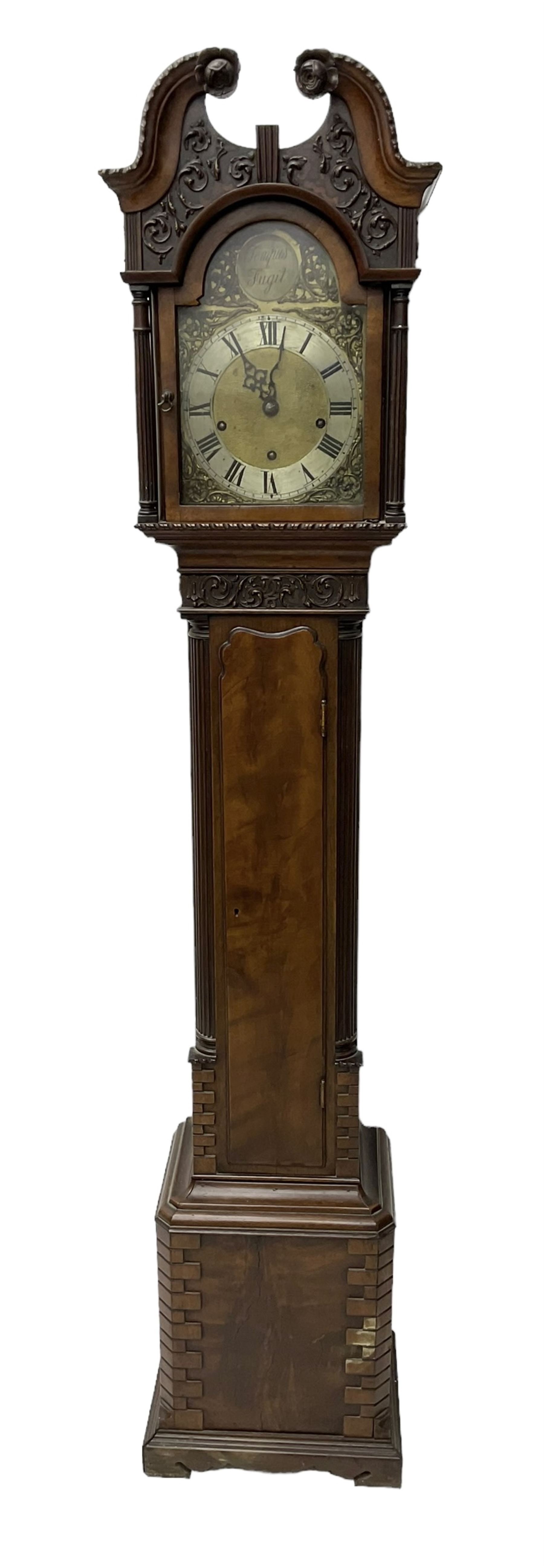 20th century - Chippendale design mahogany 8-day Grandmother clock with a profusely carved and decorated swan's' neck pediment, break arch hood door flanked by reeded pilasters with wooden capitals, trunk with a carved frieze, canted corners, three quarter reeded pilasters and a long trunk door with a wavy top, plinth with carved brickwork to the corners and raised on a shaped base, brass dial with a plain centre, cast spandrels and a silvered 