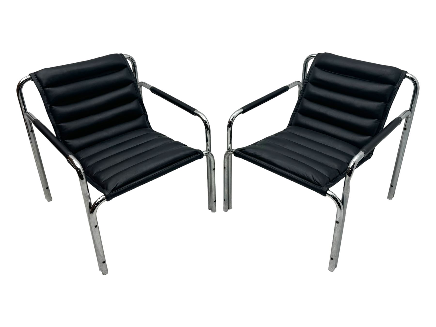 Baroumand Designs - pair of mid 20th century modernist armchairs, slung black leather seat with horizontal channel tufting, tubular chrome frame with curved arms, raised on tubular supports