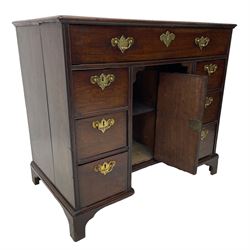 George III mahogany kneehole desk, moulded rectangular top over one long drawer, six short drawers and recessed panelled cupboard, cock-bead moulded frame, fitted with shaped brass handle plates with engraved decoration, on bracket feet 