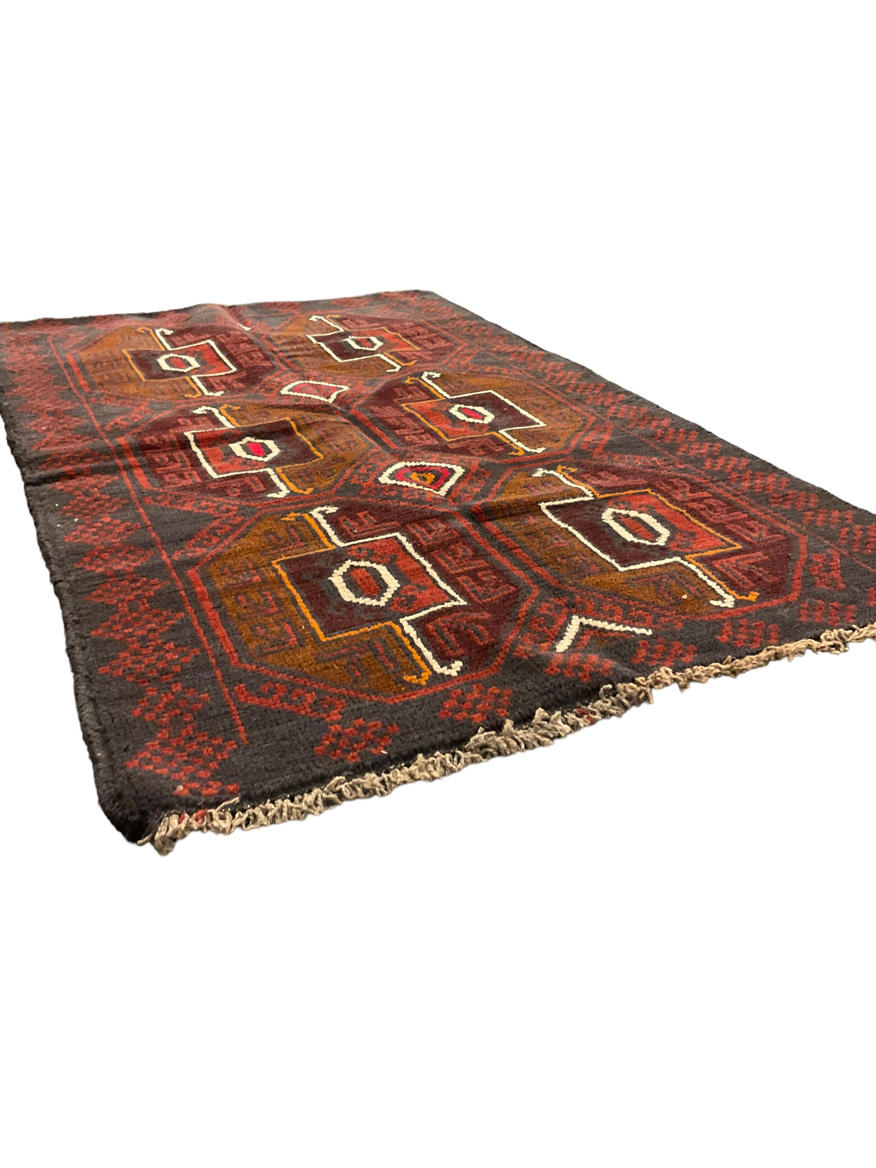 Baluchi red and blue ground rug, the field decorated with large six Gul motifs