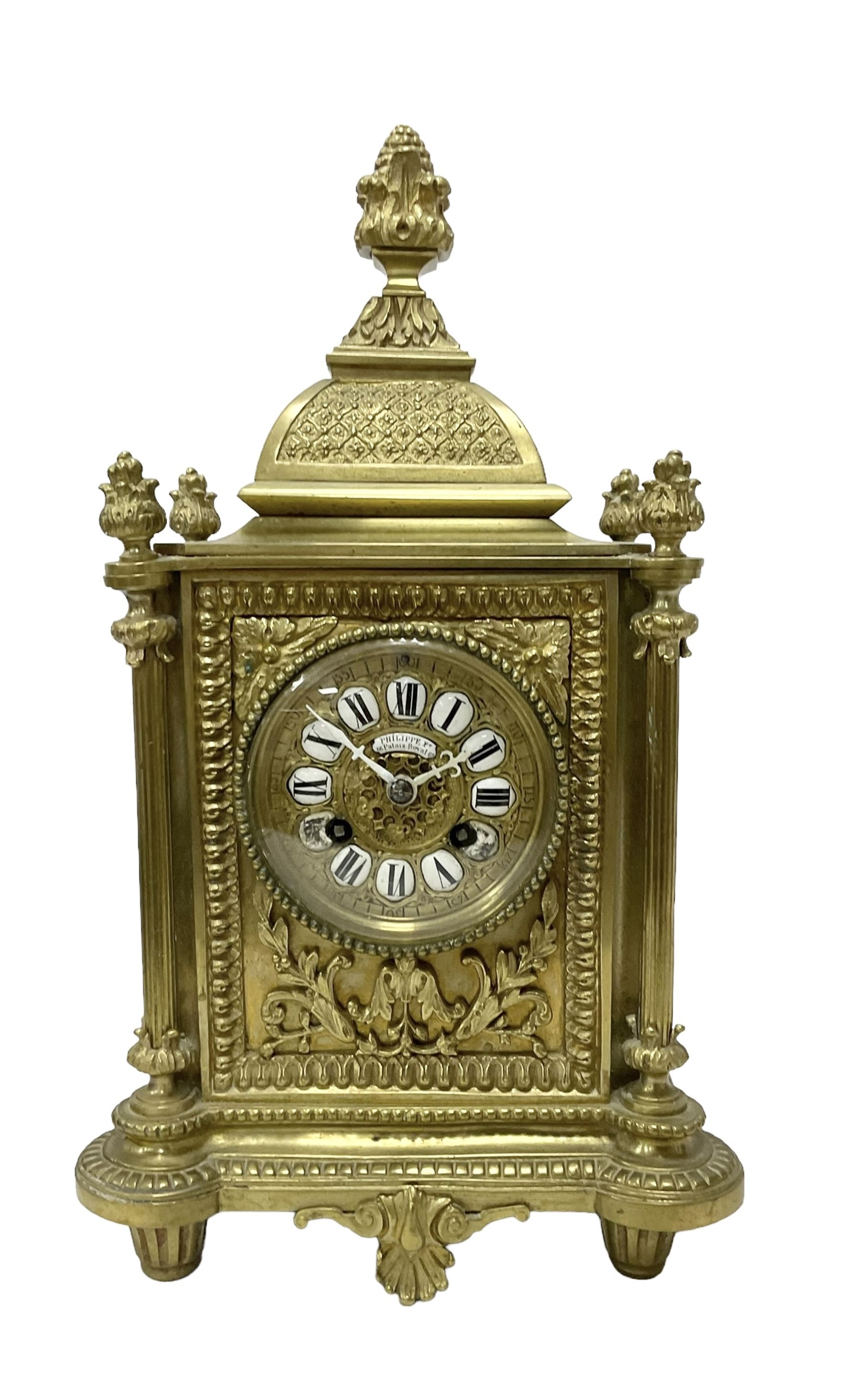 French - Brass cased 8-day mantle clock c1880, with a domed top surmounted by a pineapple finial, four reeded pilasters to the corners and raised on tapered feet, with a conforming dial with cartouche numerals, fleur-di -Lis hands and the name, Phillippe, 66 Palais Royal, Paris, twin train countwheel striking movement sounding the hours and half-hours on a bell.  With pendulum and key. 
