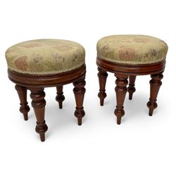 Pair of Victorian walnut circular stools, cushioned seats upholstered in floral pattern fabric, moulded seat rail over turned supports 